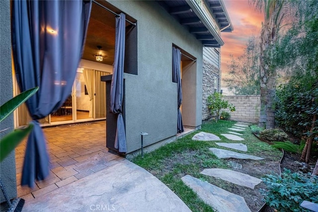 yard at dusk featuring a patio area