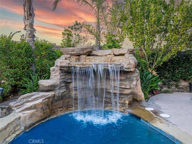 view of pool at dusk