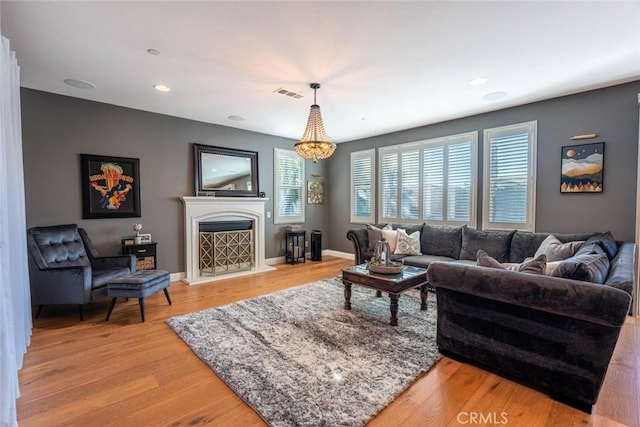 living room featuring light hardwood / wood-style flooring and a notable chandelier