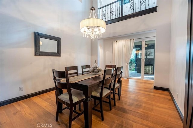 dining space with hardwood / wood-style floors and a notable chandelier