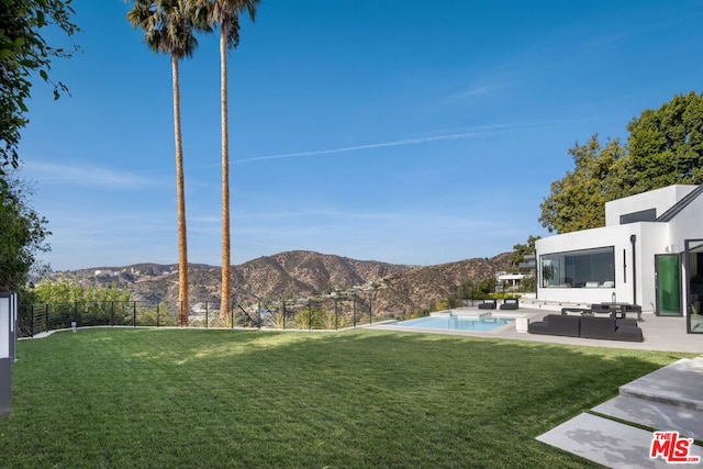 view of yard with a fenced in pool, a mountain view, outdoor lounge area, and a patio