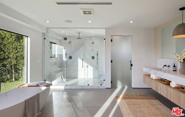 bathroom featuring separate shower and tub, vanity, and tile patterned flooring