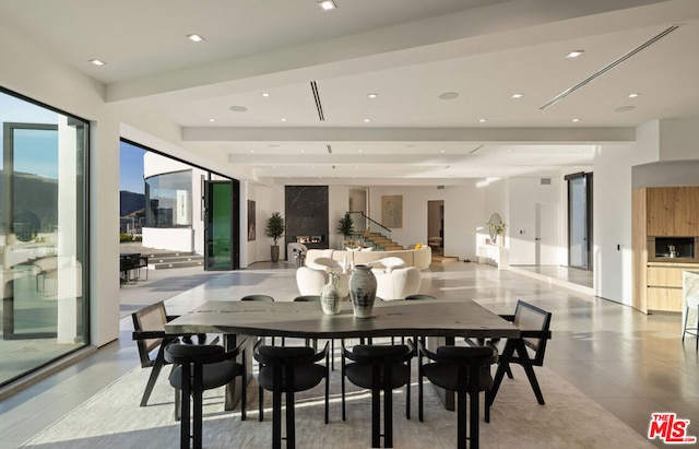 dining room with light tile patterned floors and beamed ceiling