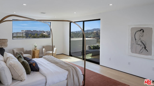 bedroom featuring a mountain view, access to exterior, and light wood-type flooring