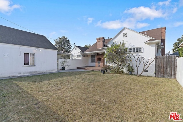 rear view of property with a patio area and a lawn