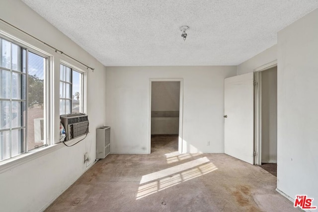 unfurnished room with carpet, radiator heating unit, and a textured ceiling