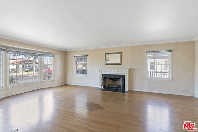 unfurnished living room featuring a high end fireplace, crown molding, and wood-type flooring