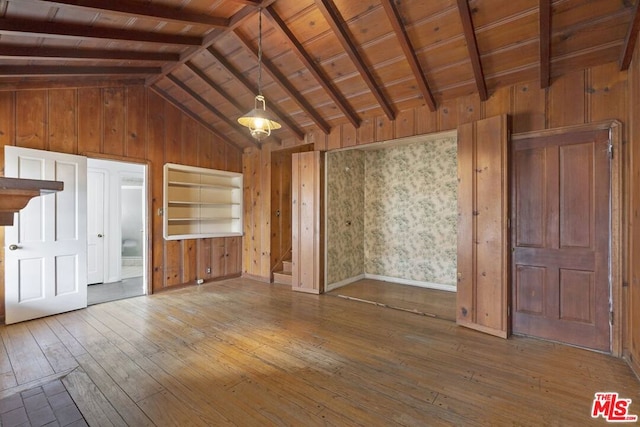 unfurnished living room with wood-type flooring, lofted ceiling with beams, and wooden ceiling