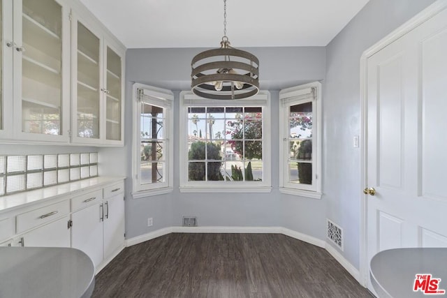 unfurnished dining area with dark hardwood / wood-style flooring and an inviting chandelier