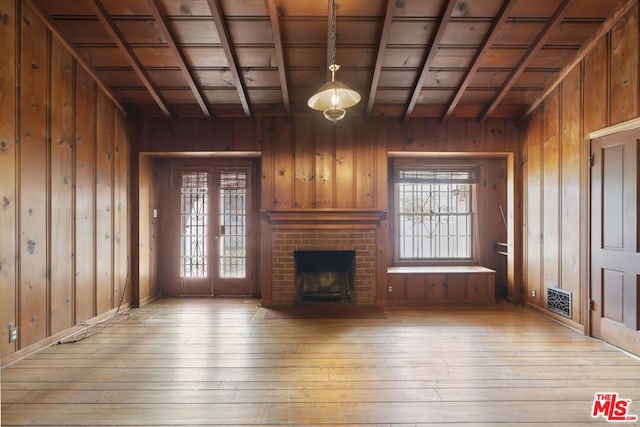 unfurnished living room with wooden ceiling, a fireplace, wooden walls, and lofted ceiling with beams