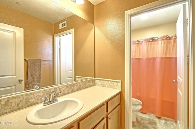 bathroom featuring toilet, vanity, and a shower with shower curtain