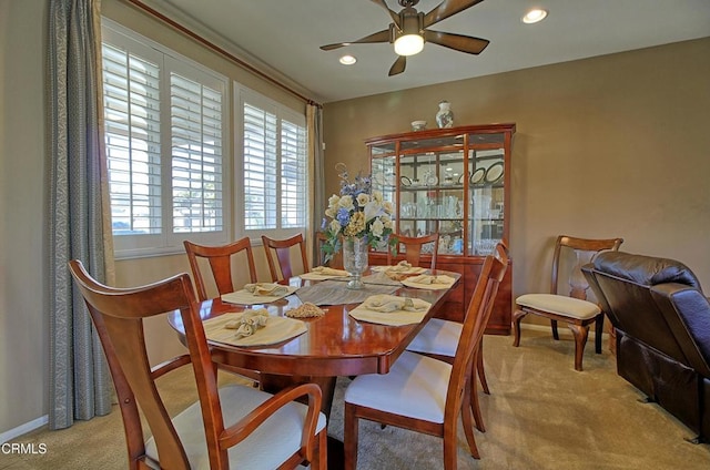 carpeted dining room with ceiling fan