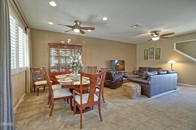 carpeted dining room with ceiling fan