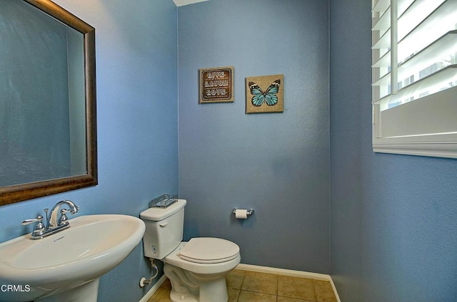 bathroom featuring toilet, tile patterned floors, and sink