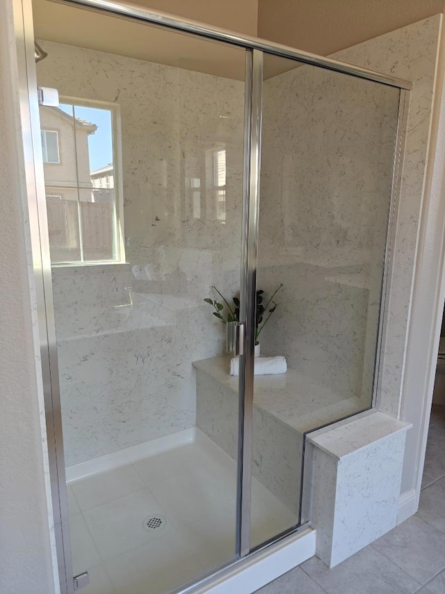 bathroom with tile patterned flooring and a shower with shower door