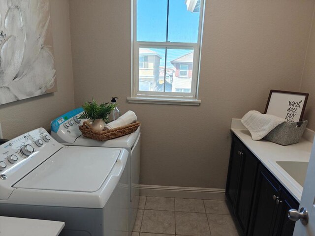 laundry area featuring cabinets, light tile patterned flooring, and independent washer and dryer