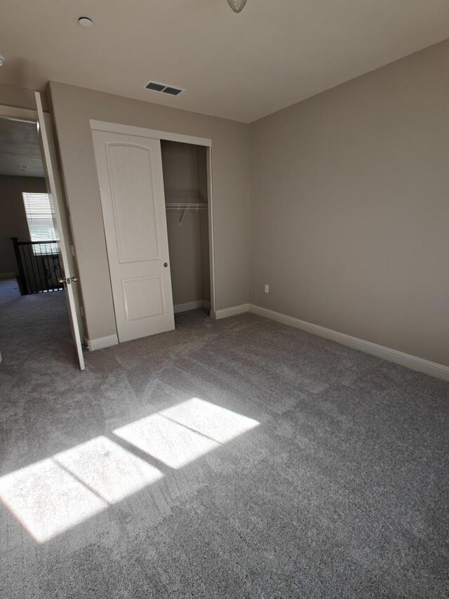 unfurnished bedroom with carpet flooring and a closet