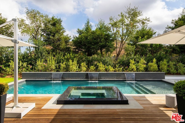 view of pool featuring pool water feature, a deck, and an in ground hot tub