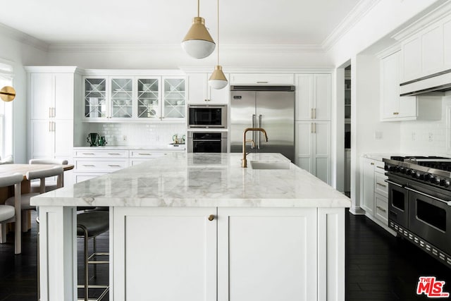 kitchen featuring decorative light fixtures, crown molding, built in appliances, white cabinetry, and light stone counters