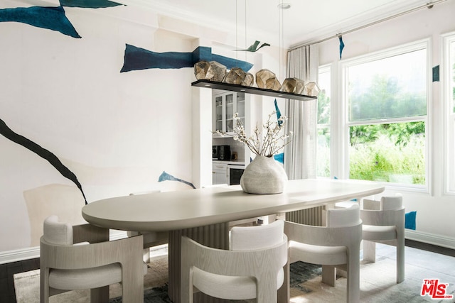 dining room with wood-type flooring and crown molding