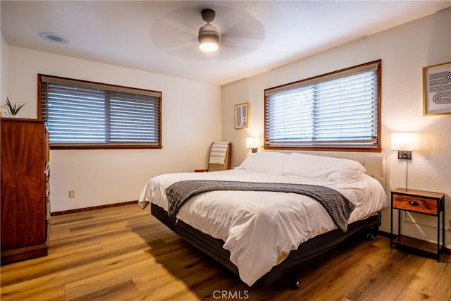 bedroom with a ceiling fan, baseboards, and light wood-style floors