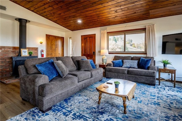 living area featuring visible vents, a wood stove, wood finished floors, recessed lighting, and wooden ceiling