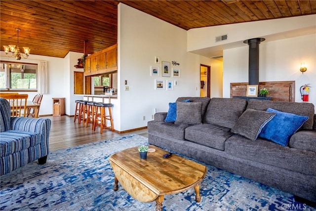 living room featuring a notable chandelier, wooden ceiling, wood finished floors, lofted ceiling, and visible vents