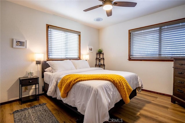 bedroom featuring a ceiling fan, baseboards, and wood finished floors