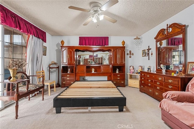 bedroom featuring light carpet, ceiling fan, and a textured ceiling