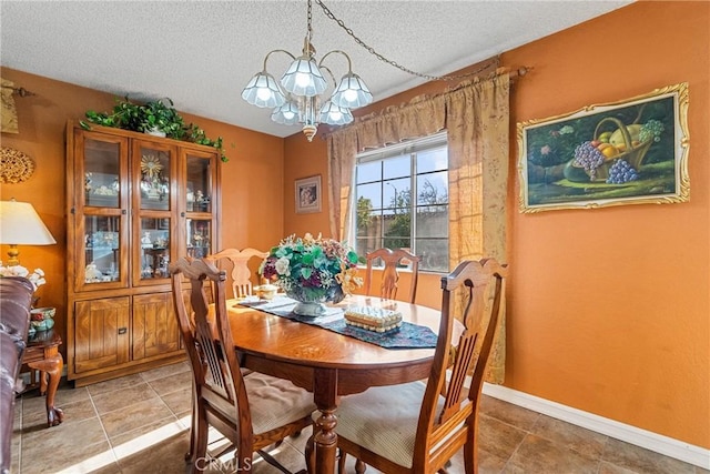 tiled dining area featuring a textured ceiling and a notable chandelier