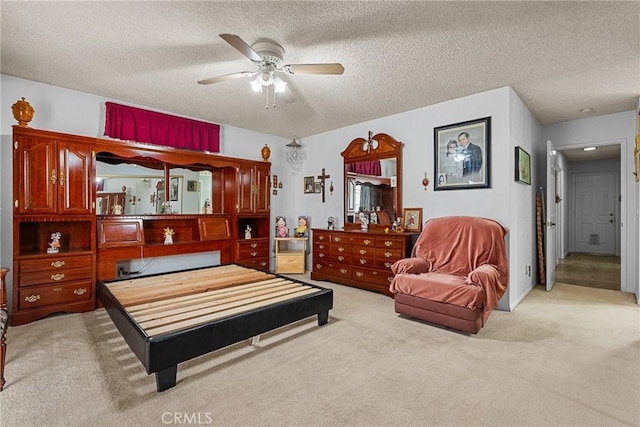 carpeted bedroom featuring ceiling fan and a textured ceiling