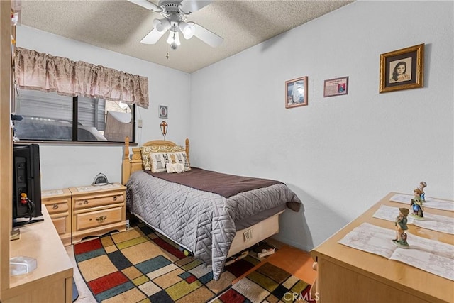 bedroom with ceiling fan and a textured ceiling