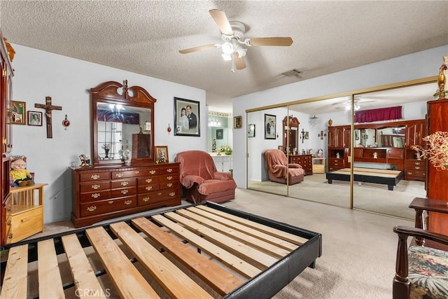 carpeted bedroom featuring a textured ceiling, a closet, and ceiling fan