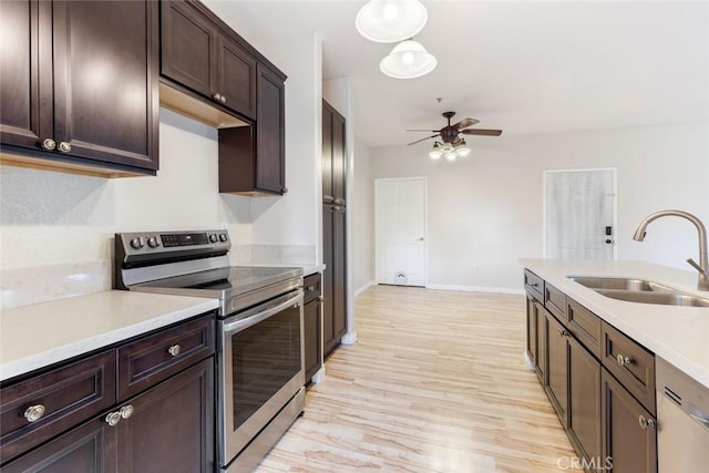 kitchen with stainless steel appliances, sink, light wood-type flooring, ceiling fan, and dark brown cabinets