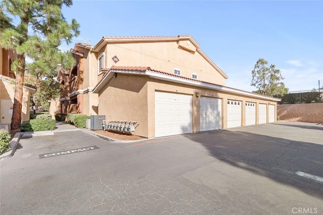 view of front of property with central air condition unit and a garage