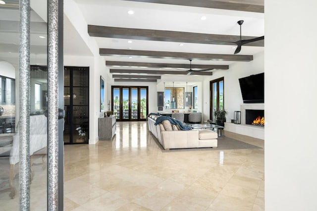 living room featuring beam ceiling, ceiling fan, and french doors