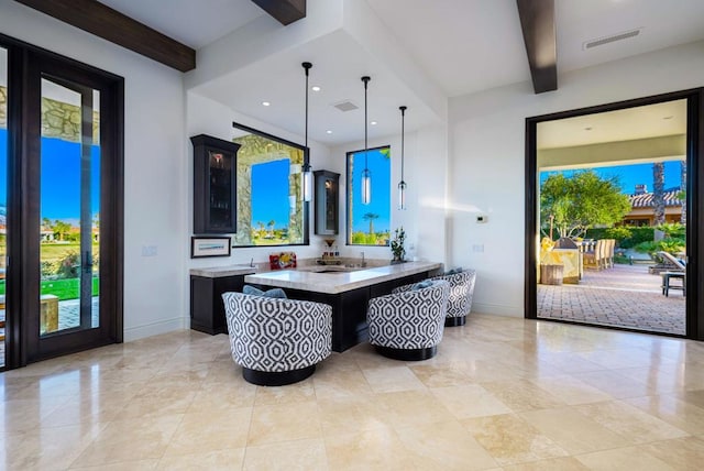 interior space with sink, a breakfast bar, beam ceiling, decorative light fixtures, and kitchen peninsula