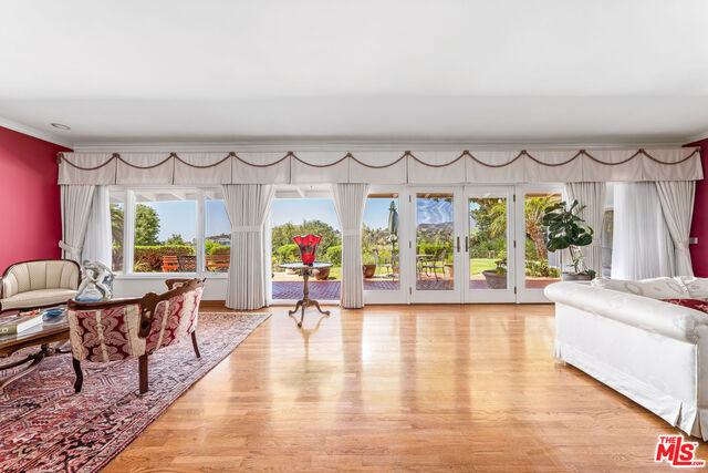 living room with ornamental molding and light hardwood / wood-style floors