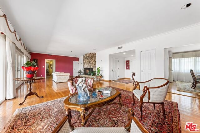 living room with a stone fireplace and light hardwood / wood-style floors