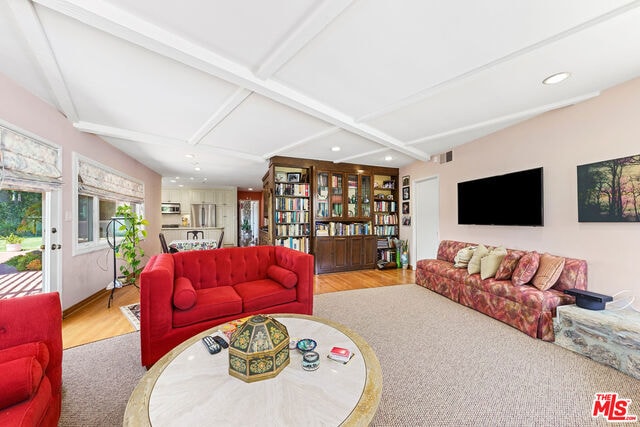 living room with coffered ceiling, light hardwood / wood-style flooring, and beamed ceiling