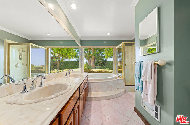 bathroom with tile patterned flooring, vanity, ornamental molding, and plus walk in shower