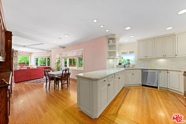 kitchen with tasteful backsplash, kitchen peninsula, dishwasher, and light hardwood / wood-style floors