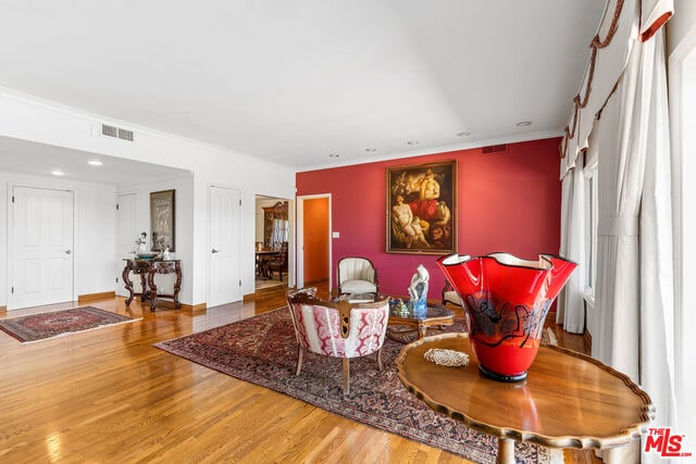 living room with crown molding and hardwood / wood-style flooring