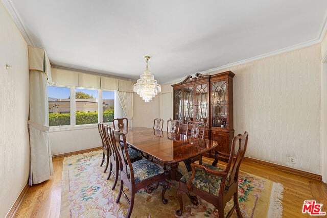 dining area featuring a chandelier, light hardwood / wood-style floors, and ornamental molding