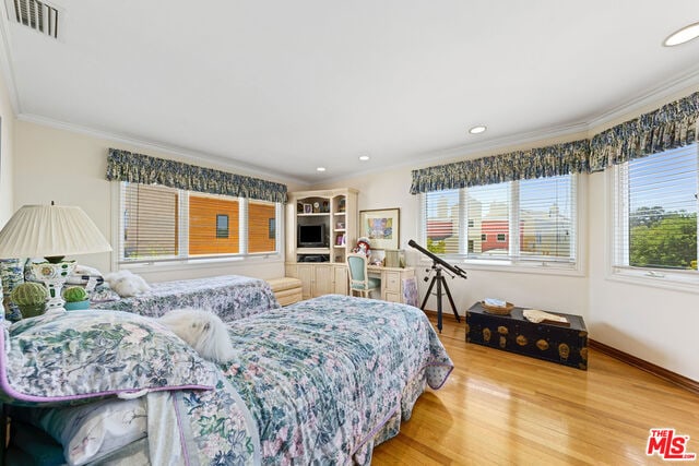 bedroom with ornamental molding and hardwood / wood-style floors