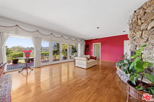 living room featuring french doors, crown molding, and hardwood / wood-style flooring