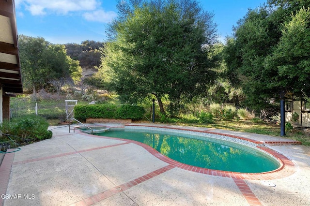 view of swimming pool featuring an in ground hot tub and a patio area