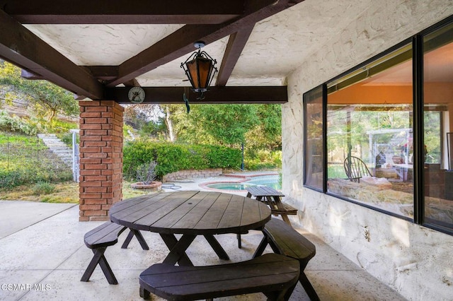 view of patio featuring a swimming pool with hot tub