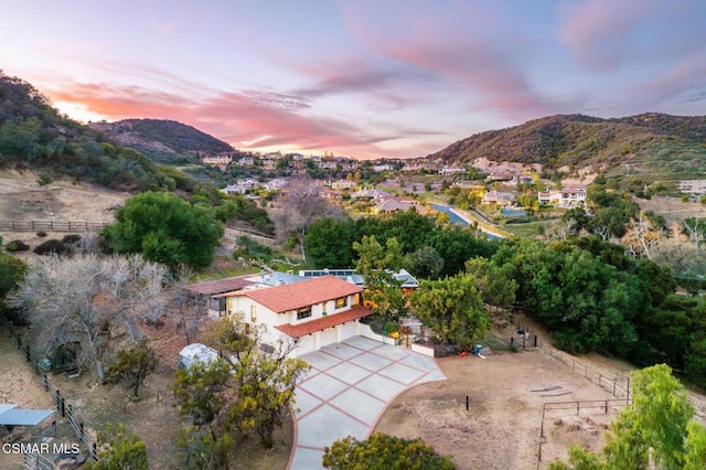 aerial view at dusk featuring a mountain view