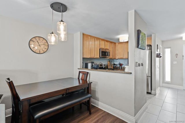 kitchen with stainless steel appliances, kitchen peninsula, and hanging light fixtures